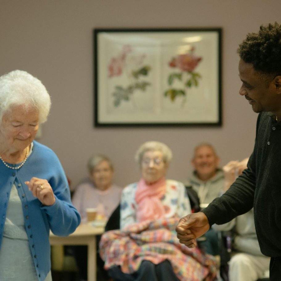 An image of a social care worker in a residential home with happy residents